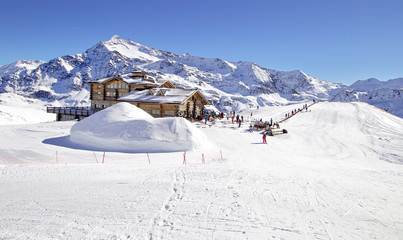 Downhill slope and apres ski mountain hut with restaurant terrace in the Italian Alps, Europe,...