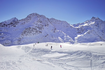 Fototapeta na wymiar High mountains under snow in the winter. Slope on the skiing resort, European Alps