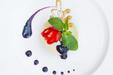 Creme caramel served with sweet syrup and strawberry