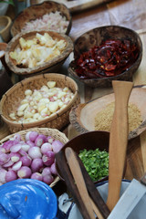 Thai condiment, onion, garlic , chili and lime in wicker baskets.