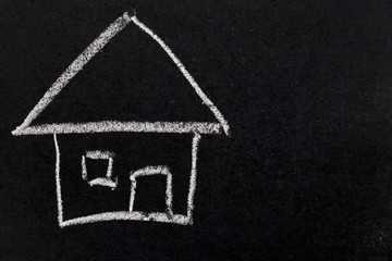 White chalk drawing as house shape on black board background (Concept of dream home, happy family)