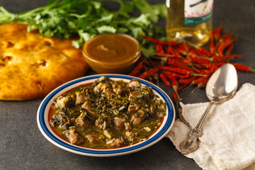 Chashushuli surrounded by vegetables on a wooden table