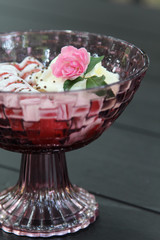 Pink rose decorated on preserved banana with syrup, coconut milk and whip cream.