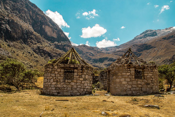Casas de pastores en la cordillera de los Andes Peruanos y de fondo un cielo azul y montañas