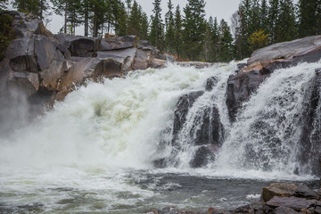A beautiful waterfall in a central Norway. Colorful autumn landscape at the river. Natural fall scenery.