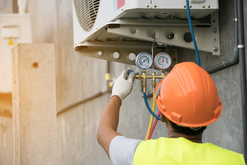 asian man runs the air-conditioning refrigerant from the tank