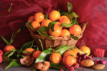 tangerines. still life  a wicker basket full of mandarin, lit by the light of a candle, Christmas atmosphere