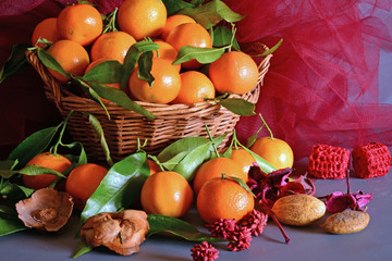 tangerines. still life  a wicker basket full of mandarin, lit by the light of a candle, Christmas atmosphere