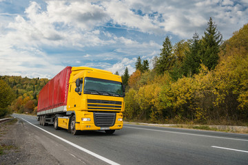 Red-yellow truck on the road in Europe