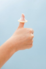 Fototapeta na wymiar Thumbs up with condom on thumb.