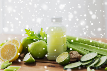 bottle with green juice, fruits and vegetables