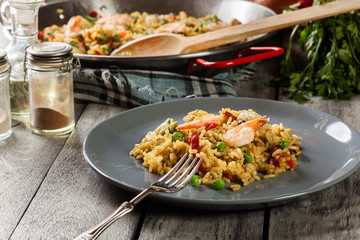 Traditional seafood paella with shrimp, fish and chicken seved in plate.