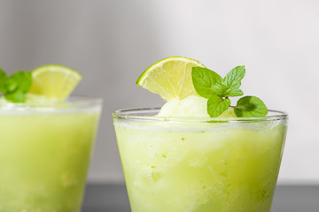 Cocktail juice with lime, mint and ice. Bar drink accessories on black table background.