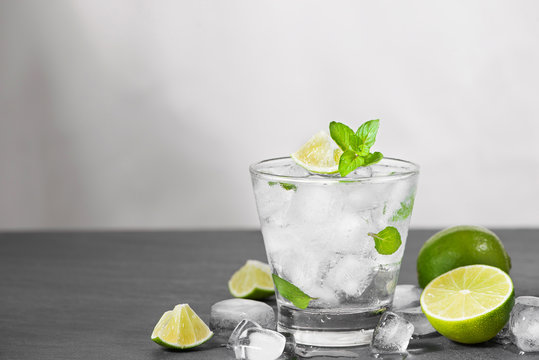 Mojito cocktail with lime and mint in glass on a grey stone background