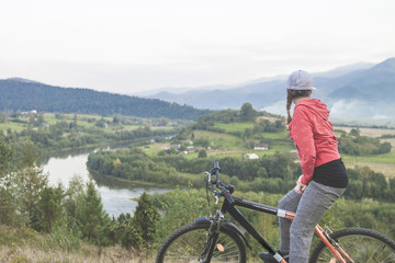 Young woman bike, river mountains biker