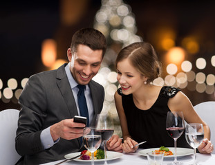 smiling couple eating main course at restaurant