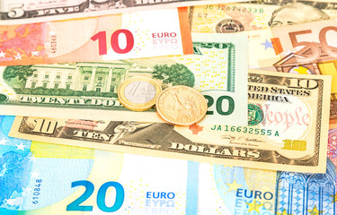 Fototapeta na wymiar Euro and one dollar coins lying over different currency banknotes euro and dollars
