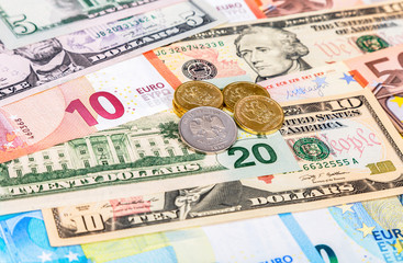 Russian rubles coins lying over different currency banknotes euro and dollars close up