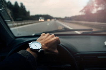 business trip, road ahead, driver with a wristwatch, behind the wheel on the road