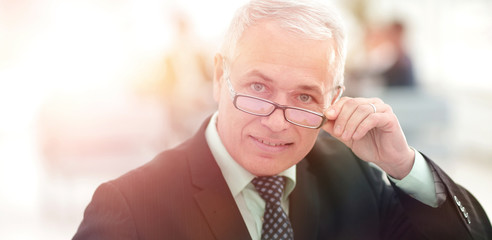 Portrait of mature businessman with  colleagues interacting on b