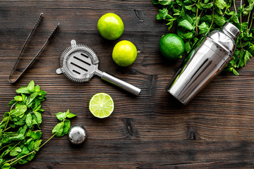 In the bar. Shake mojito. Lime, mint., barman tools on wooden background top view