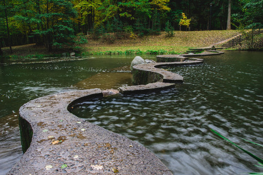 a pedestrian path through the river. Autumn Park. The river Svisloch flows through the park Drozdy reservoir in Minsk.