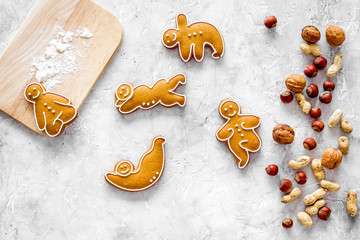 Healthy food for sportsman. Cookies in shape of yoga asanas near nuts on stone background top view