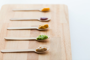 vegetable or fruit puree or baby food in spoons