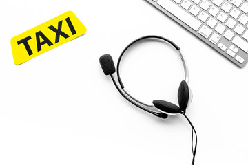 Taxi service online. Taxi label, keyboard, headphones on white background top view copyspace