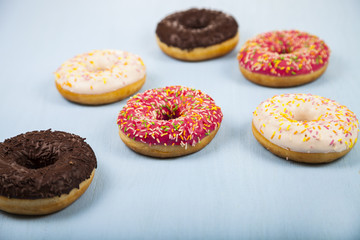 Multicolored donuts  on a wooden background.