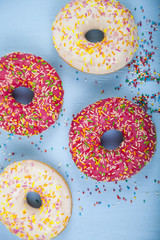 Multicolored donuts  on a wooden background.