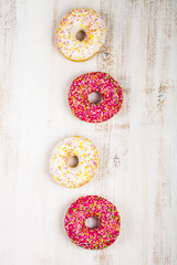 Multicolored donuts  on a wooden background.