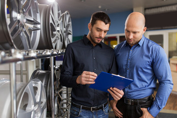 customer and salesman at car service or auto store