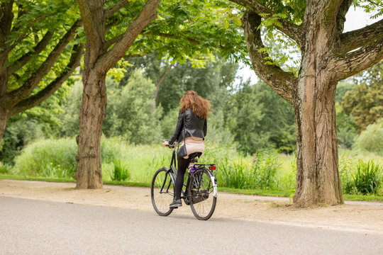 Girl biking on a omabike in the Amsterdam Vondelpark
