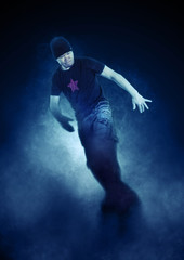 Obraz na płótnie Canvas Young man break dancing on dark smoke background