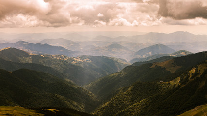 Obraz premium Beautiful view on Rodna mountains with dramatic sunshine through clouds at Romania country