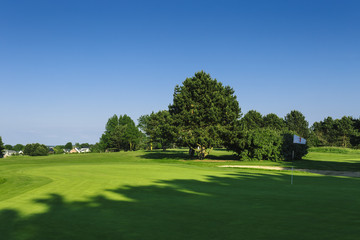 General view of a green golf course on a bright sunny day. Idyllic summer landscape. Sport, relax, recreation and leisure concept