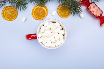 Christmas and New Year. Marshmallows in a red mug on a blue background. Top Vieux