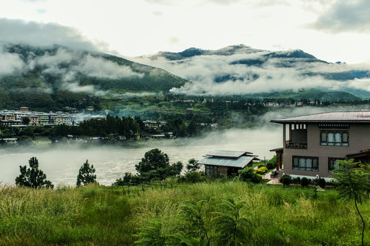 Bhutanese village near the river on a foggy day at Punakha, Bhutan