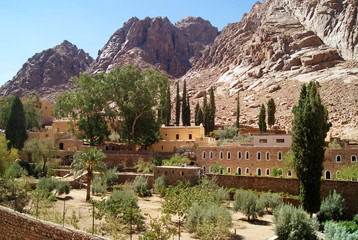 Obraz premium Garden of Saint Catherine's Monastery in the desert on the Sinai Peninsula, Egypt - one of the oldest working Christian monasteries in the world - against the background of sun-burned lifeless rocks