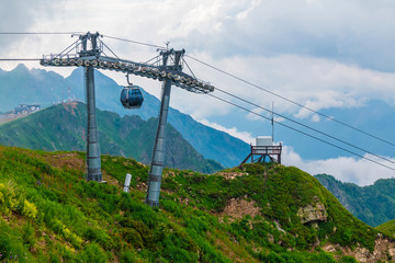 Cableway on the background of ridges, peaks and clouds in Rosa Khutor, Russia