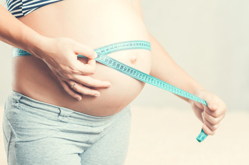 pregnant woman measuring tape measures the volume of the stomach