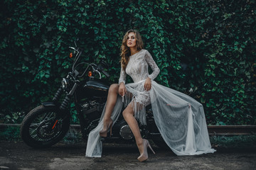 Young girl bride on a new man's motorcycle. Waiting for his prince