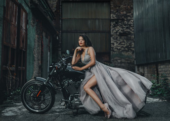 Fototapeta na wymiar Young girl bride on a new man's motorcycle. Waiting for his prince