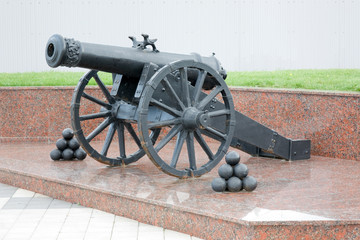 An old cannon on a granite pedestal - 178715326