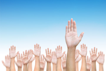 Business crowd raising hands high up on blue skies background. Concept Business / Question / Ask / Idea. 