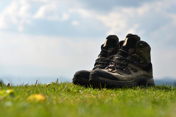 hiking boots at the grass and background mountains 