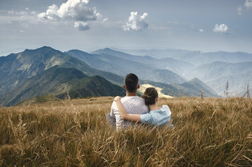 Naklejka premium man and woman sitting on top of mountain