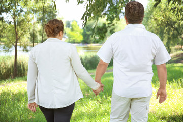 Obraz premium Overweight couple in park on sunny day