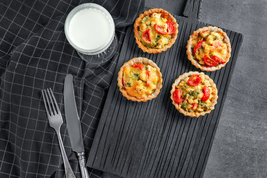 Delicious crispy tarts with broccoli on wooden board